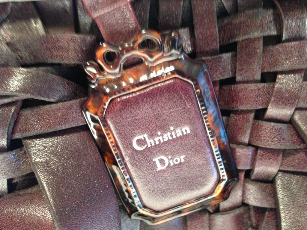 Brought back into design from a 1947 collection
 Incredible basket weave of beautiful warm reddish leather
 Matching Louis XVI picture frame tag with Dior logo.
 Faux tortoise shell frame top with rings and serpents.
 Snap clasp. 
 Faux