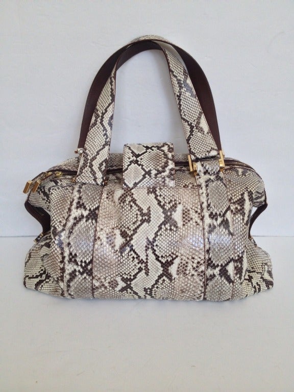 Bright and fabulous! This large off-white and charcoal brown bag is a refreshing take on python, and would make a gorgeous work, overnight, or carry-on bag. 

The top closes with a wide strap and turn clasp, in addition to an exposed gold zipper.