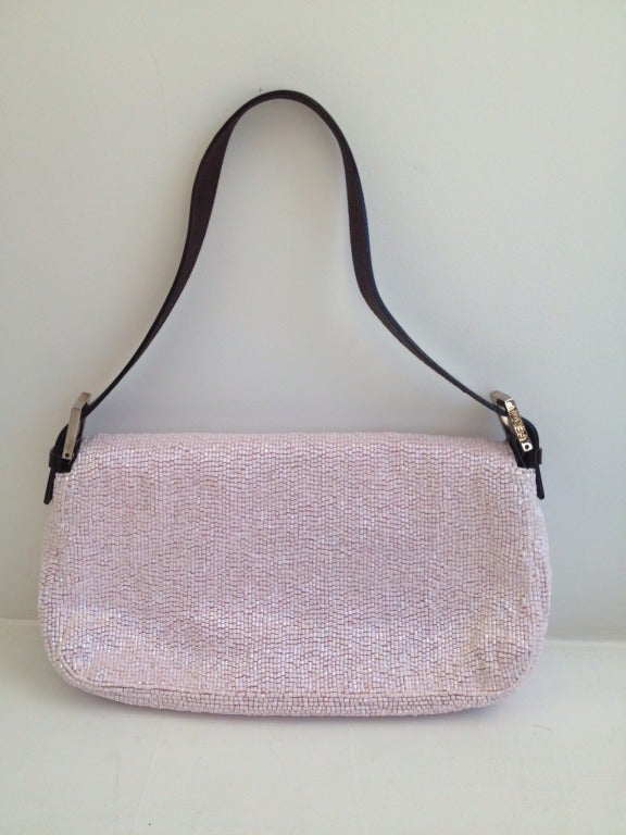 A bit of icing for your evening look!

This slim, petite Fendi is covered in sparkling, shell-pink beading and finished with chocolate leather at the handle, front strap, and underside of the flap. The front is closed with a hidden magnetic snap.