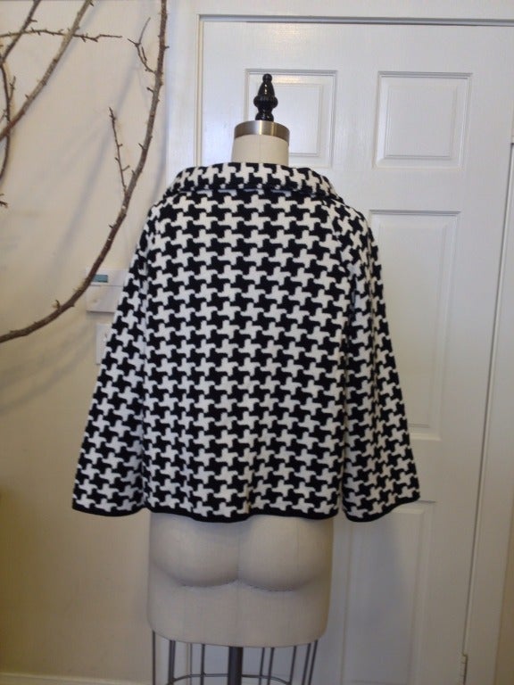 Oh la la! This fetching houndstooth is sure to turn some heads as you stroll down le boulevard.

The rounded collar, three-quarter sleeves, and bold pattern put a fun, modern spin on this soft wool sweater jacket. 

Large round buttons cover