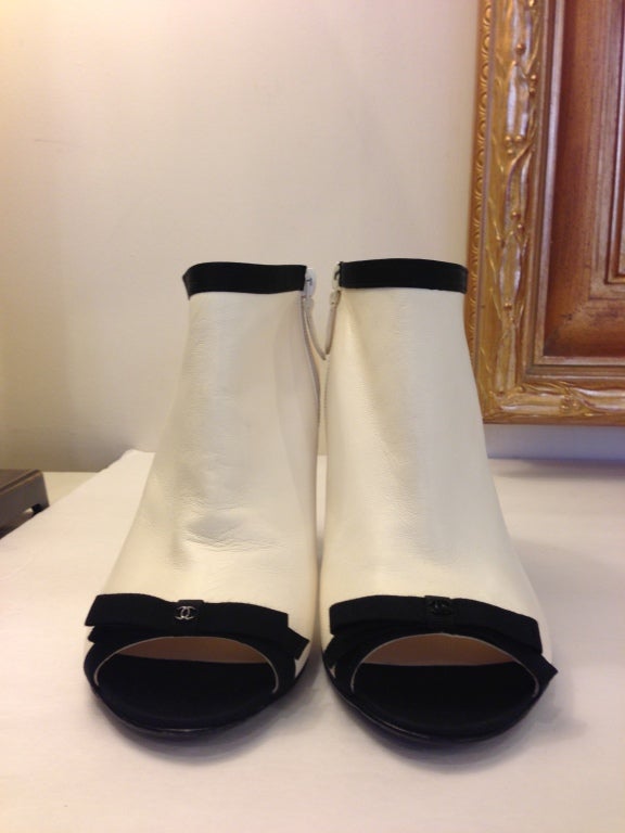 Step out on the town in these Chanel booties.  They are made of the softest white leather with black grosgrain trim around the ankle and over the toe.  These booties have understated Chanel glamour with a small black 
