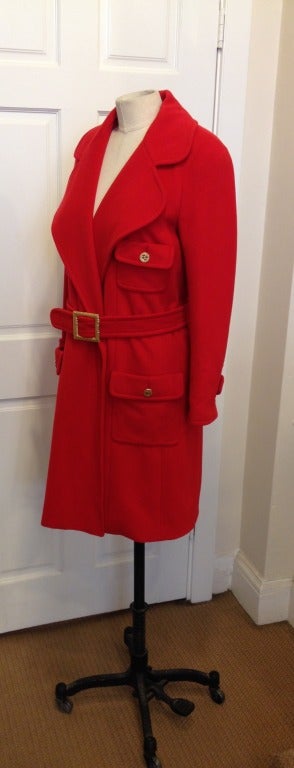 Stop traffic in this bright red winter coat!  Soft cashmere will keep you warm, especially with your hands nestled into the deep front pockets.  All four pockets have a gold colored button with the CC emblem.  Three additional buttons are on each