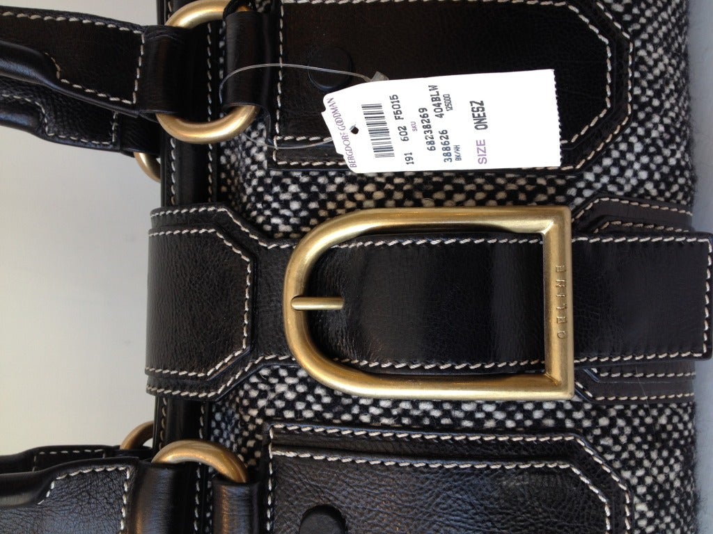 Just what the doctor ordered!  This fabulous handbag is perfect for carrying all the accoutrements that go with being a stylish woman.  The black and white tweed body with black leather accents can be easily paired with any outfit.  The handles