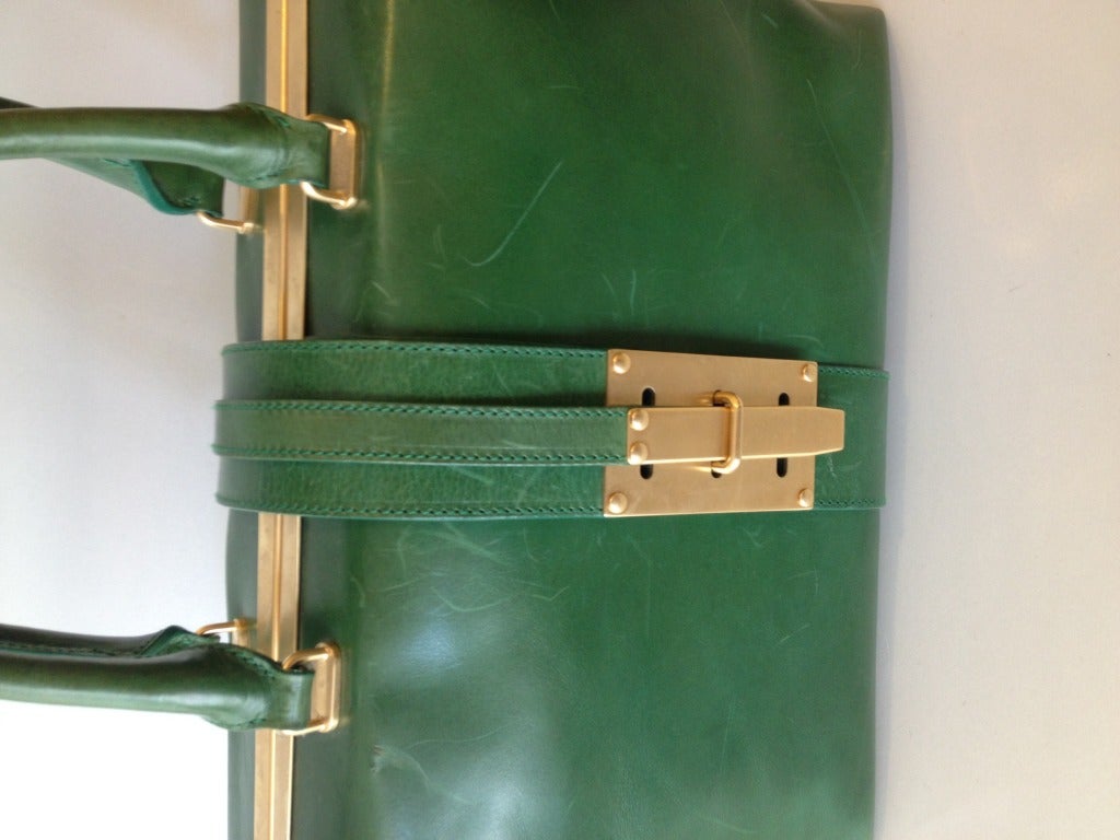 You will feel like a queen carrying this bright structured bag in hand.  Gorgeous green leather holds its shape, but is soft to the touch.  The two handles stand 5 inches above the bag.  The unique clasp adds beautiful detail; gold tone hardware