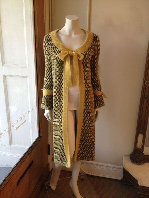 Stay warm during chilly spring nights with this Missoni coat.  The yellow and dark gray tweed of this beautiful piece has a scoop neck that ties with a bow as well as just above the wrists.   There is a yellow belt at the waist giving it a playful