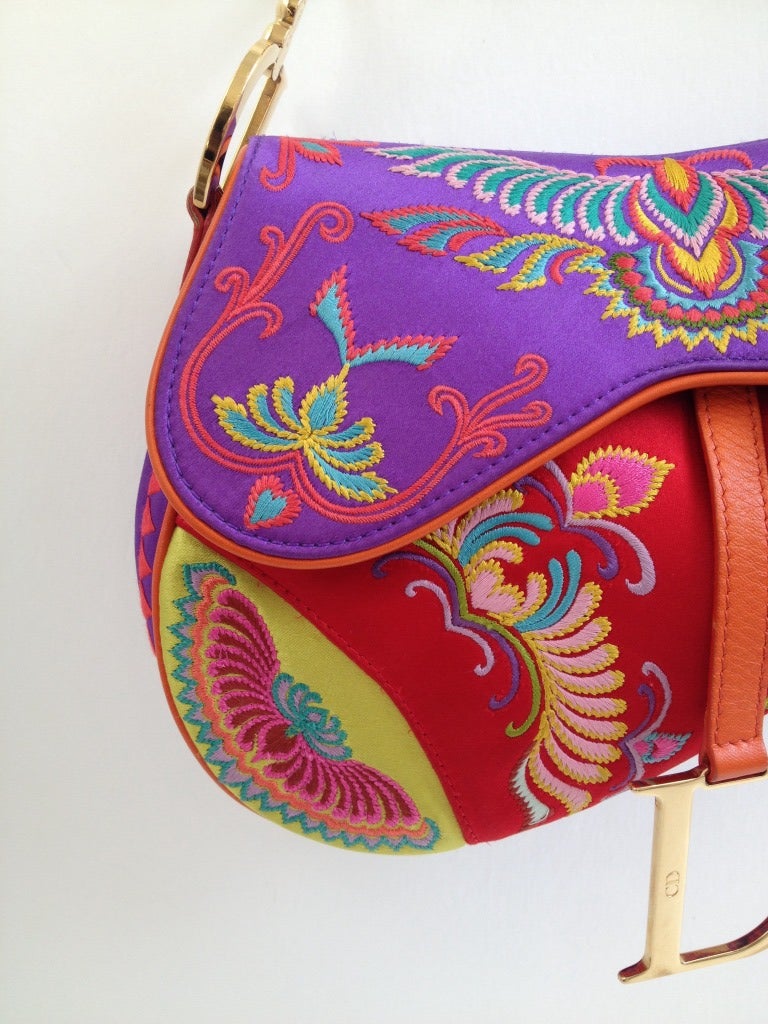 Stand out from the crowd with this brightly colored purse!  Rich, vibrant silks in purple, red, and chartreuse are pieced together and trimmed in bright orange leather.  Intricate embroidery creates the beautiful pattern that winds acoss the bag. 
