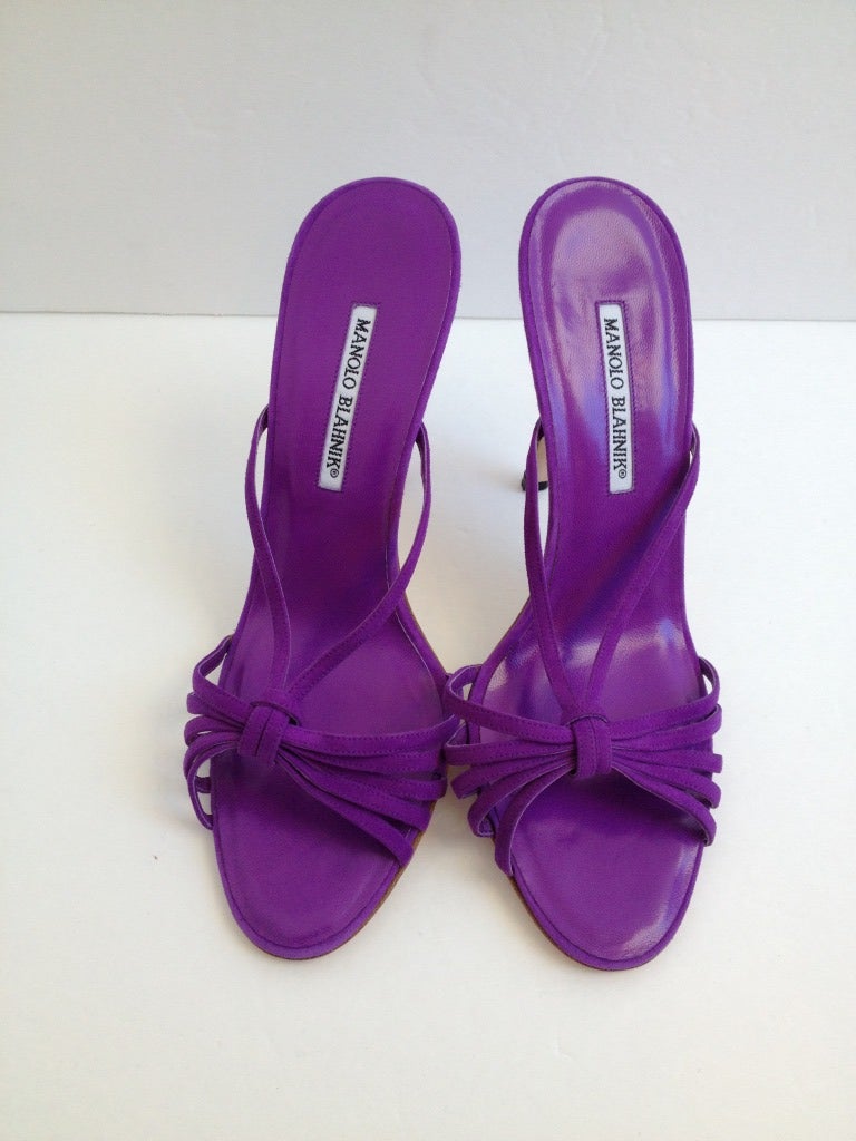 Be adventurous in these purple suede Manolo Blahnik mules! The front of the shoe is decorated with 5 straps with a 6th strap connecting to the side of the vamp. They have a 4.25 inch heel, and are perfect for adding a pop of color.  A great way to