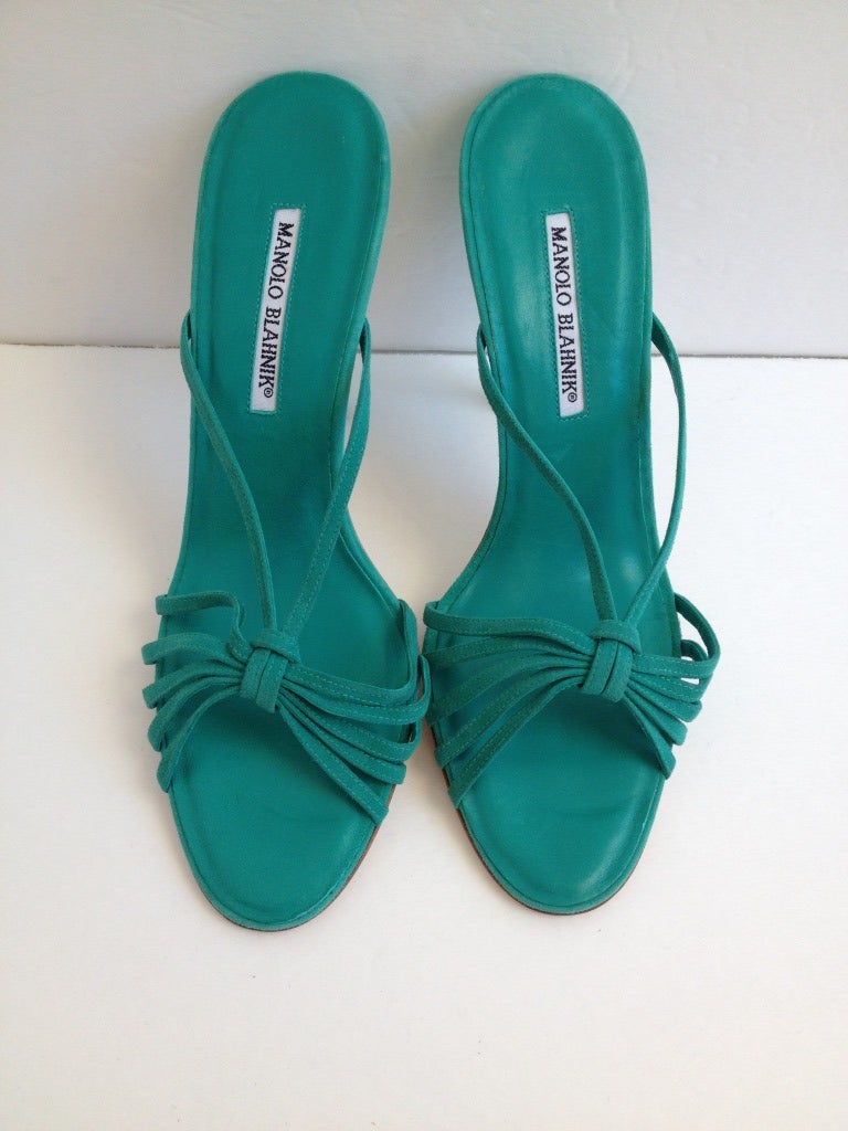 Be adventurous in these teal suede Manolo Blahnik mules! The front of the shoe is decorated with 5 straps with a 6th strap connecting to the side of the vamp. They have a 4.25 inch heel, and are perfect for adding a pop of color.