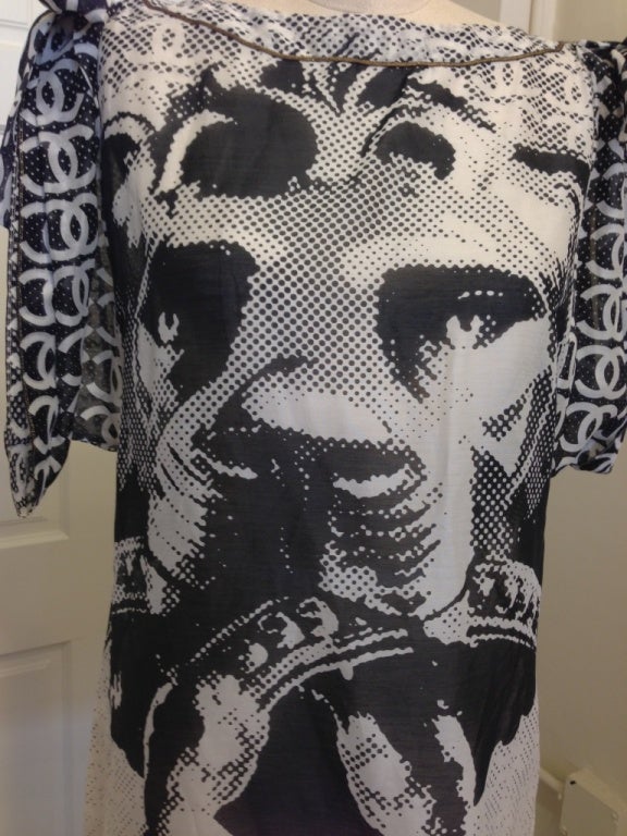 Classic black and white Chanel with a pop art twist. A giant lion (similar to a door knocker) with 2 huge Chanel C's in its mouth, the sleeves have the classic 2  C design, tiny polka dots in the background. The blouse is tunic length, great to go