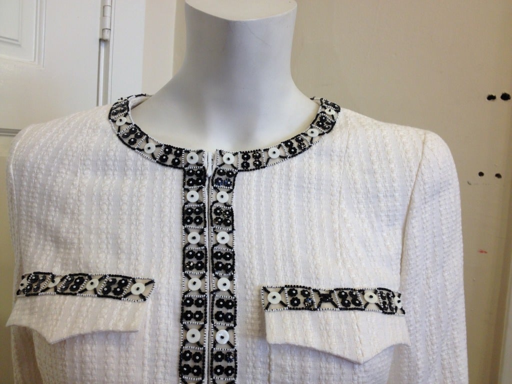 This jacket is the epitome of class.  A crisp, white cotton and linen blend is perfect for a versatile light weight jacket.  Small black and white beads trim the collar, zipper, waist, upper pockets and cuffs.  Petite black flower beads are