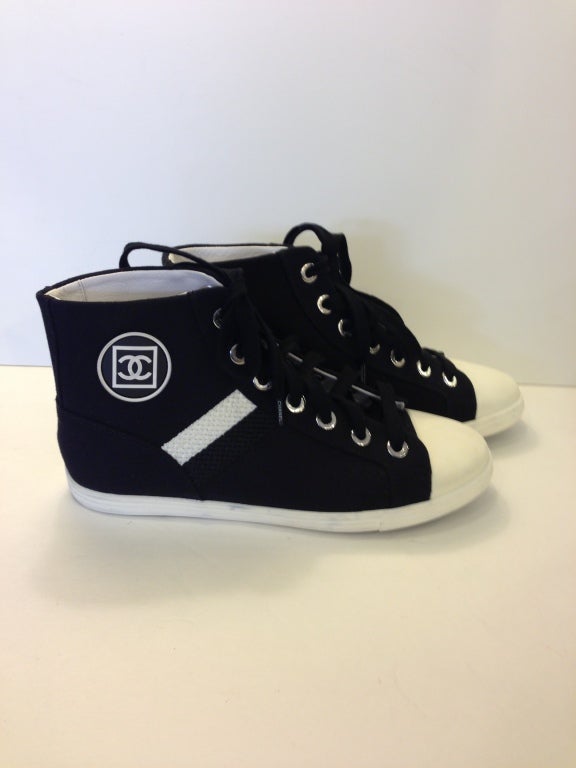 The statement sneaker of the season...
~Chanel logo on the side
~Black and white strip on on side of each shoe
~Chanel written large on tongue
~White leather lined
~Chanel written on all grommets

This item is guaranteed authentic. 
Shoes do