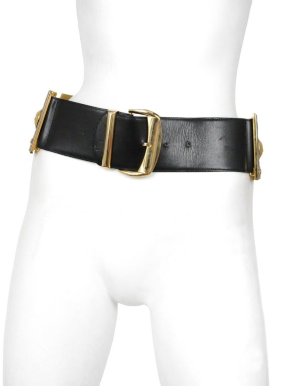 Large square shields with black embossed leather inset into gold squares accented with gold medusa studs and tacks coming together to create and insane waist belt.