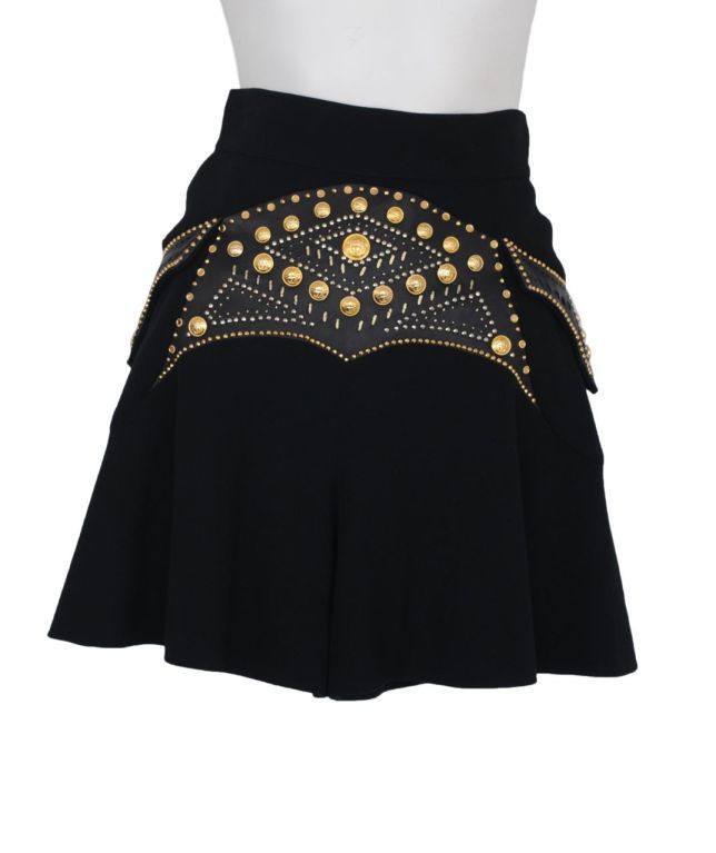 Black crepe pleated mini skirt with leather inset at waist with gold stud & tack detail.  Back zip closure.
