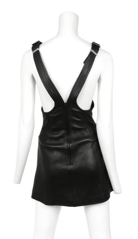 Black lambskin leather jumper with cross straps. Six Medusa buttons at the high waist and adjustable straps.