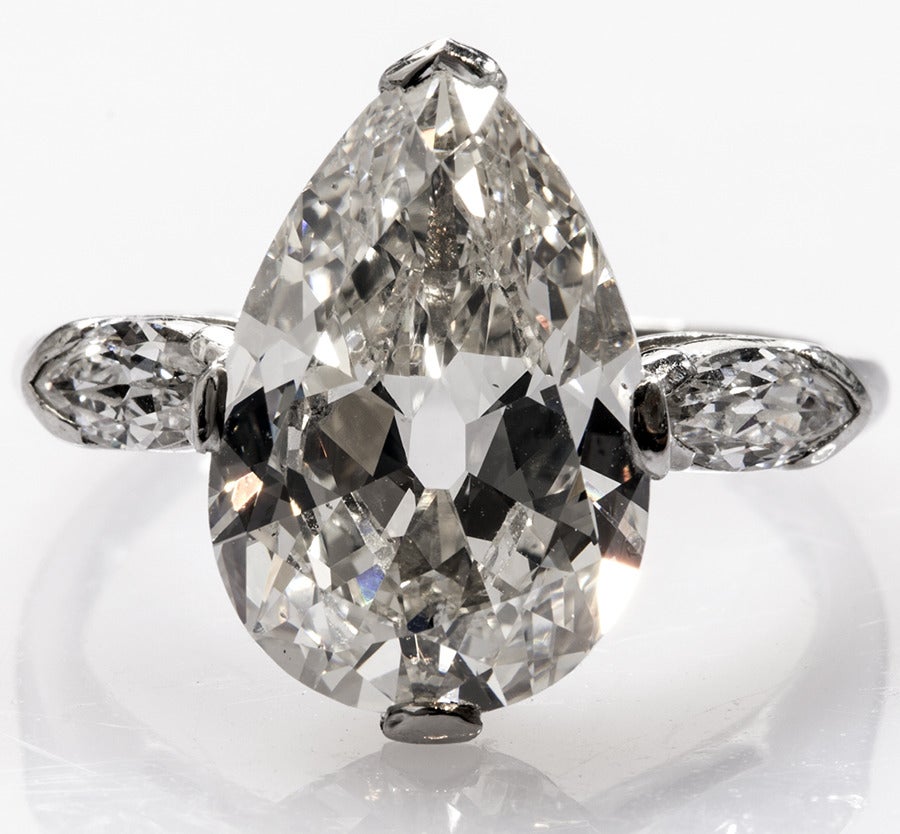 Amazing Old European cut pear shaped Diamond stradled by a Marquis cut stone on each side and set in Platinum. The ring is about four carats total weight, and reflects light beautifully.
