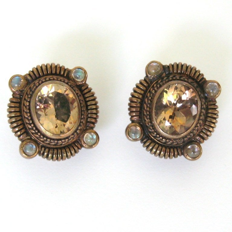 Early 1990s Dweck Clip On Earrings

    Smokey Quartz with moonstone accents
    Bezel set Stones
    Hallmarked Stephen Dweck 925

Measures .85 in x .95 in

This is  among a vast collection of Jewelry that was stored away for years and never