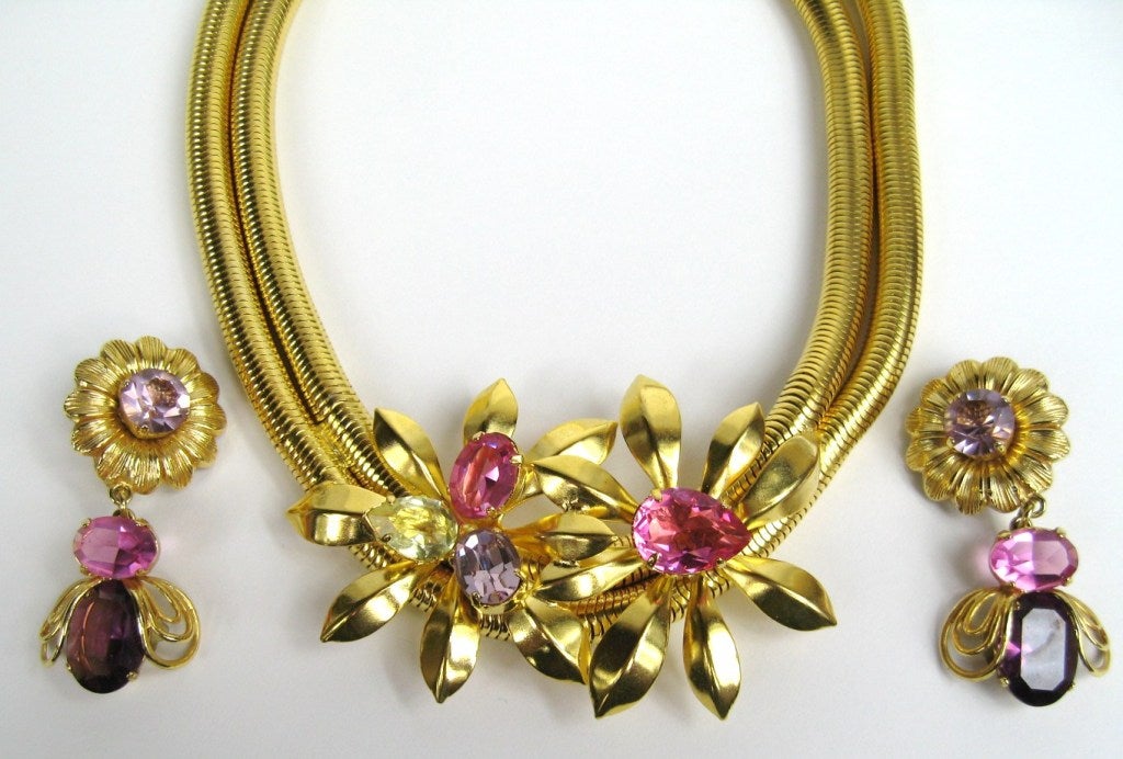 New Old Stock from Parisian Artisan Ferrandis.

 
Double Snake chain with 2 large flowers at the base on the necklace. 
Pinks, Purples prong set crystals made of the colors on this set

16