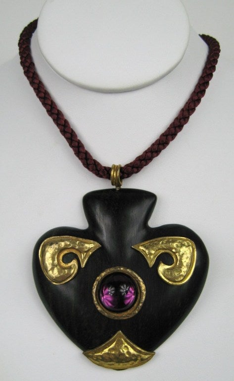 Wood, Gilt and Glass make up this large Yves Saint Laurent Necklace. Hung on a burgundy rope.
20 in long braided rope 
Heart is 3.25 in wide  x 3.25 in L

Again, another piece that is was a collection of a prominent Westchester County family. This