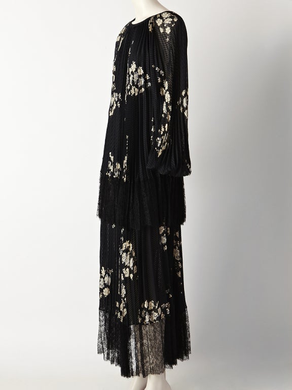 Andre laug, printed silk, pleated, tired dress with a border of fine black lace hemming each tier.The print is an ivory tone floral pattern on a black silk jacquard ground. Dress has a 