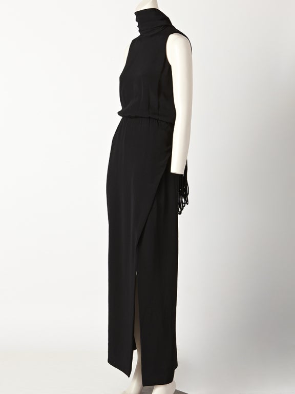 Geoffrey Beene , heavy, black silk crepe gown, with halter cut sleeves, slightly gathered waist, slim skirt with slit, and a dramatic attached scarf that ties around the neck, creating a 