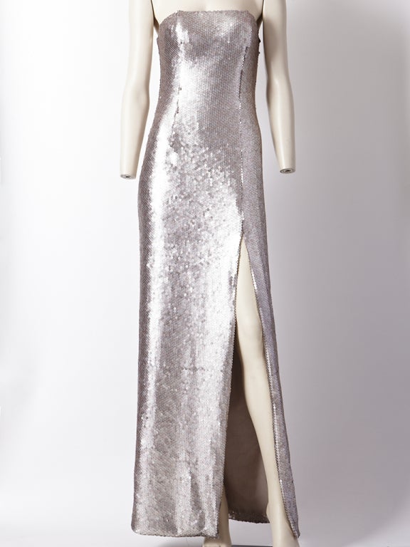 Vickey Tiel, iridescent, platinum toned, sequined fitted strapless gown with deep front slit.