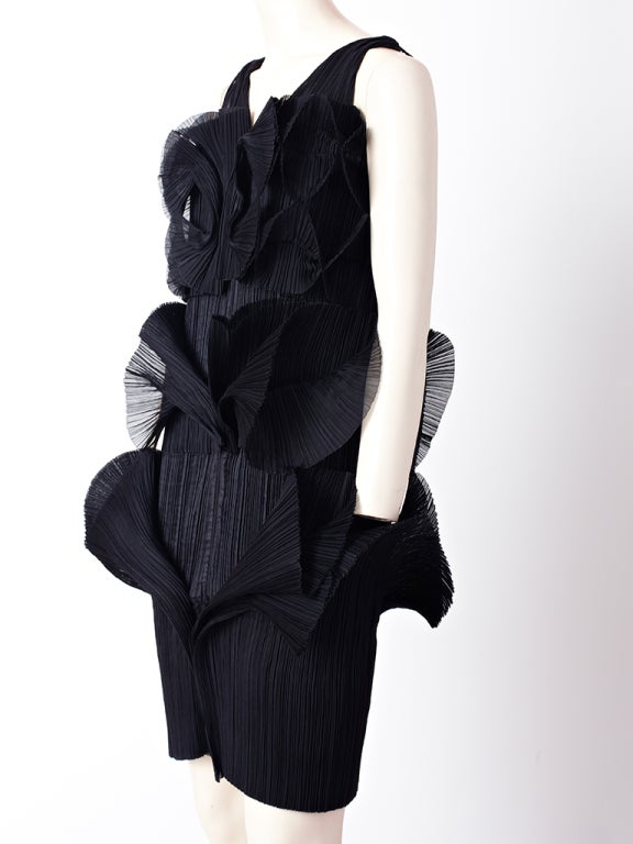 Issey Miyake, pleated, sleeveless dress. Body or the dress is straight with pleated ruffles in 3 tiers along the the bust line, waist, and just below, the hip.
Dress closes with a front zipper that extends from the top to the hem.
Issey Miyake