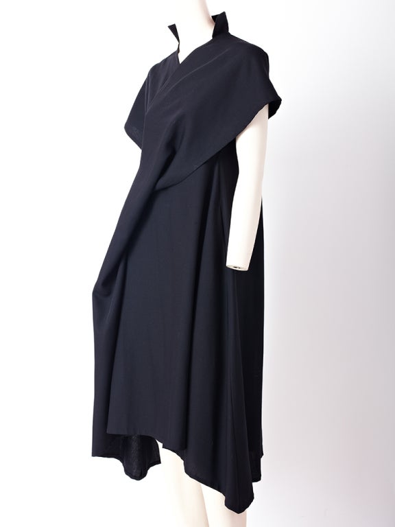 Navy wool, Yohji Yamamoto, black day dress with asymmetric hem and front draped bias panel coming from shoulder and going down to
the hem.Stand up collar and short kimono like sleeves..