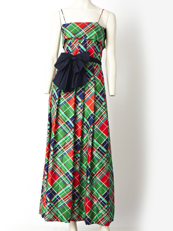 Pauline Trigere, silk, red, green and navy blue, plaid gown, with spaghetti straps and navy faille belt with bow. Plaid is placed on the bias..