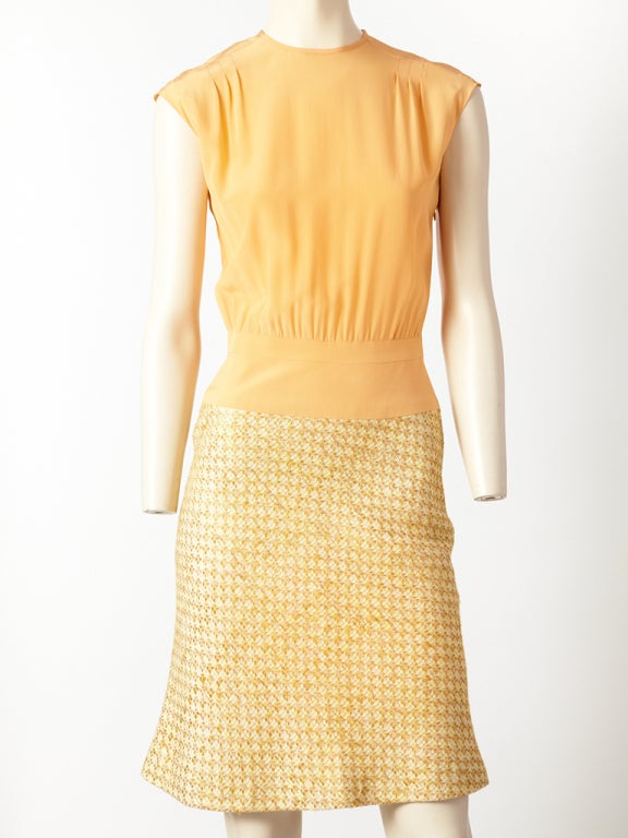 Chanel, silk and tweed day dress. Bodice is silk, apricot tone, jeweled neckline, with a cap sleeve and a banded drop waist line. Skirt is slightly A line, bias cut, shape in an ecru and ivory tone tweed. From the 