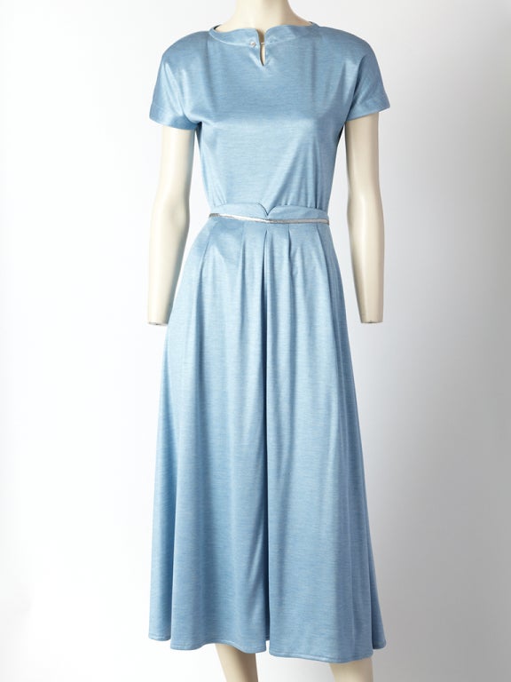 Geoffrey Beene blue jersey knit 2 piece ensemble. Top has a short sleeve with a curved neck detail. Skirt is full, high waisted with a silver band detail and an inverted pleat in the center front. Comes with matching scarf  also trimmed in silver