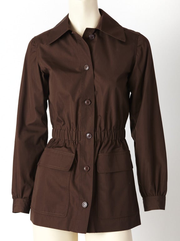 YSL, chocolate brown, cotton poplin, safari jacket with an elastic waist and deep hip, flap pocket detail. Top stitching detail at the collar, shoulders and around the pockets C. 1970's