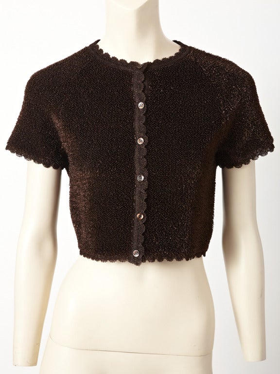 Azzedine Alaia, chocolate brown, knited, collarless , short sleeve, Cardigan/Jacket with a textured, raffia exterior finish. Jacket is embellished with a scalloped edging.