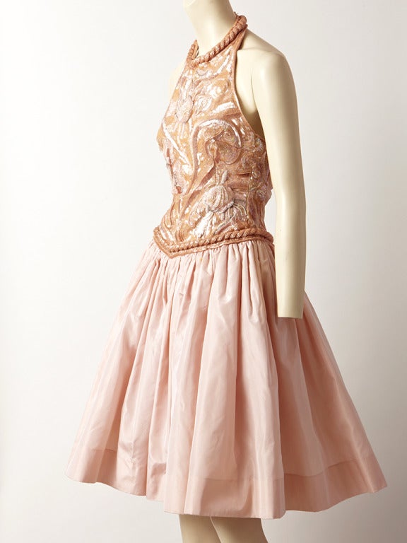Louis Feraud, ballet slipper pink, halter neck, cocktail dress.
Taffeta skirt is gathered and  slightly dropped waist line. Open back bodice is a combination of a floral pattern bead work and sequins. Back of bodice is ruched taffeta.
C. 1980's