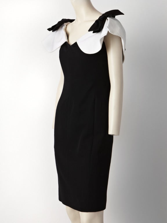 Yves Saint Laurent, wool gaberdine, dress with a white cotton faille capelet  that sits off the shoulders with black bows at the shoulder and center back. Body of the dress is fitted and straight.