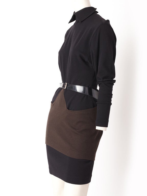 Alaia, bown and black wool knit belted dress. Dress has two, brown panels attached at the waist that wrap around the hips and belts at the waist. Dolman sleeves and high pointed colllar with snap closures at the back of the neck.