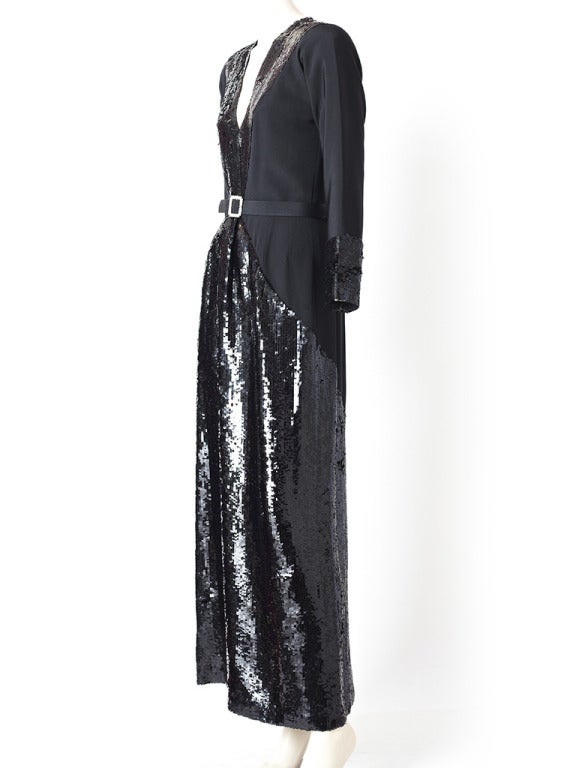 Geoffrey Beene, black, silk crepe and sequined gown.
Sequined panels growing down the from of the dress with a deep V décolleté. Long sleeves with sequined cuffs. Skirt has sequined panel insets down the front and back of dress. Comes with a back
