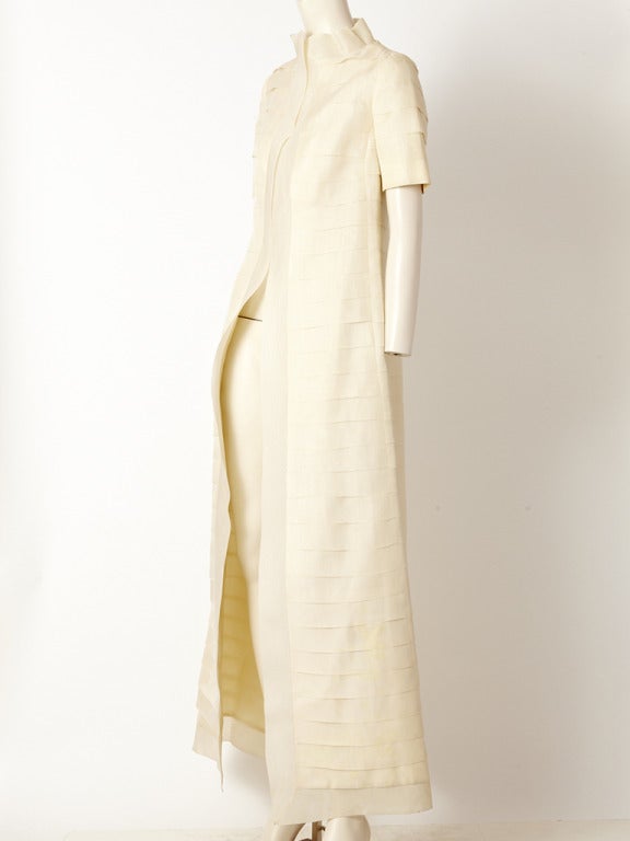 Bill Blass, ivory, organza, evening coat with a stand up collar, horizontal pleat detsil, along the body of the coat and short sleeves.