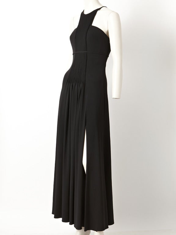 Ralph Rucci, Grecian, inspired, jersey gown. Halter style neckline with a pin tucked panel starting at the neck and ending at the middle hip of the dress.
The bodice of the dress is fitted. The dress gathers in the middle at the hip.
There is a