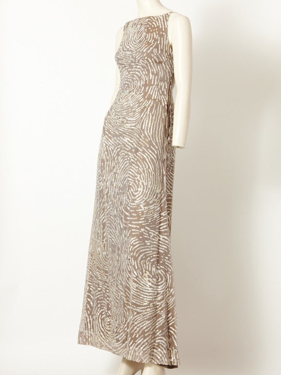 Oscar de la Renta, taupe colored, chiffon,gown with a bateau neckline, and a
spiral, silver sequin overall pattern embellishment.