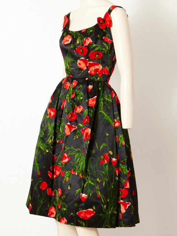 Nettie Rosenstein,, late 50's cocktail dress in a vibrant red poppy flower pattern against a black satin background. The poppies are in velvet. Dress is sleeveless with a scoop neckline, fitted bodice and full gathered skirt with petticoat.
Bodice