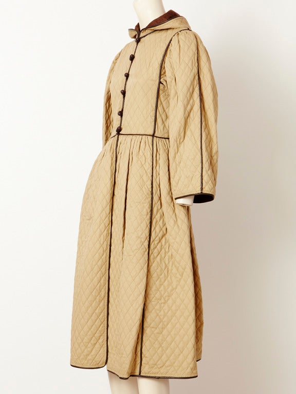 YSL, khaki, heavy cotton, quilted coat with hood. Bodice is slightly fitted with 
a gathered skirt. Coat is trimmed in fine chocolate leather. C. Late 70's.