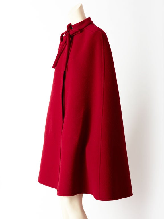 Lanvin, bordeaux, double face wool cape with mandarin collar and tie at neck. Cape interior has patch  pockets  to place your hands<br />
to balance the coat on your shoulders.