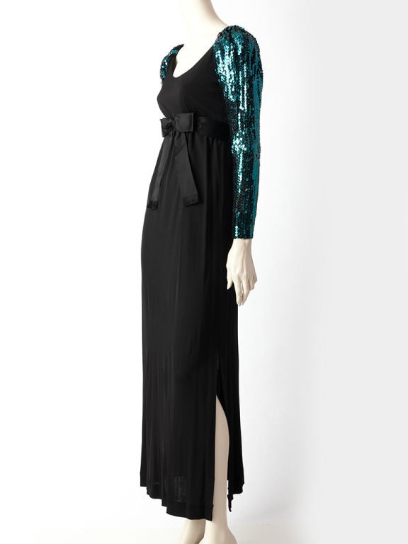 Mollie Parnis matter jersey empire waist evening dress with a satin bow under the bust and turquoise sequined long sleeves, that sightly puff at the shoulder.