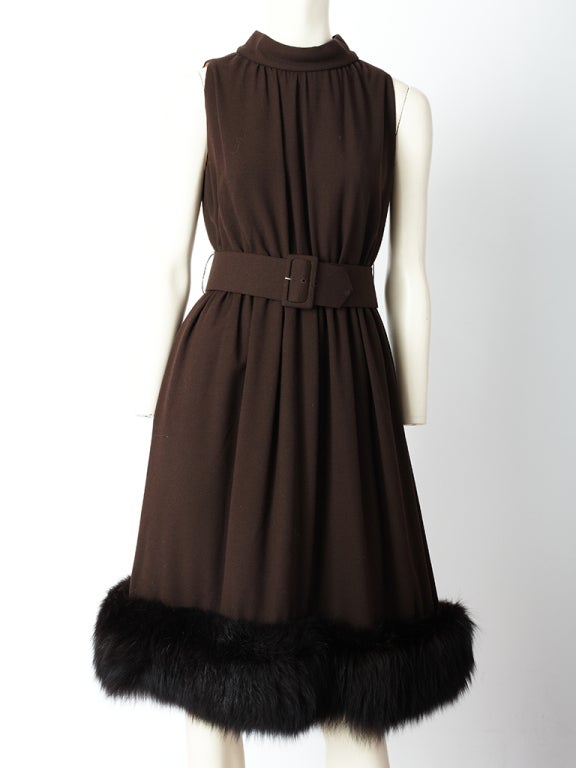 Chocolate brown, wool crepe cocktail dress with fur hem. This dress has a halter, neckline that has gathering at the neck.<br />
The waist is gathered as well with a wide self belt. Matching jacket is cropped to the waist with passementerie