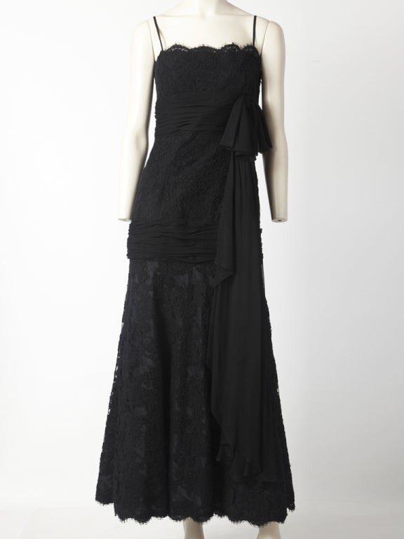 Carolyne Roehm, black, guipure lace gown with spaghetti straps and chiffon cummerbund under the bust and a bow detail of the same fabric. Another chiffon, ruched panel is placed horizontally just where the thigh starts. Below the chiffon panel, the