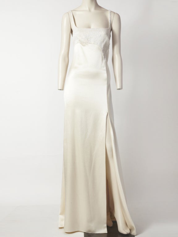 Ralph Rucci, ivory hammered satin gown with  geometrically placed, beading detail at the bust, neckline and back bodice. Dress is has a deep front, side slit with a dramatic bias cut, train, back panel that puddles on the floor.