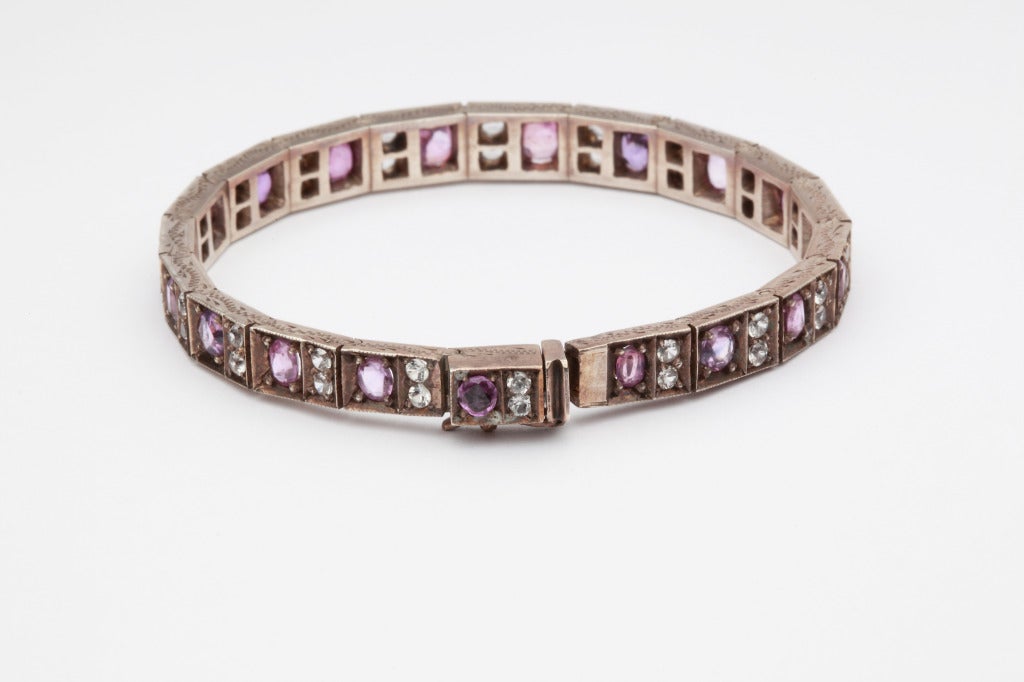 Set with 38 white circular-cut sapphires weighing approximately 2,36ct's and 19 pink oval-cut sapphires weighing ca. 7,41ct's. Mounted in Silver. Weight: 30 g.