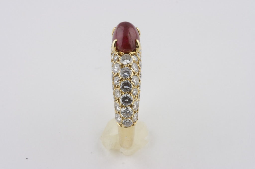 This ring is composed of 62 full cut round brilliant diamonds of very high quality equaling approximately 2 carats.  The pave' diamonds in 18k yellow gold is typical of Cartier's work in the 1980's and 1990's.  The cabochon ruby weighs approximately