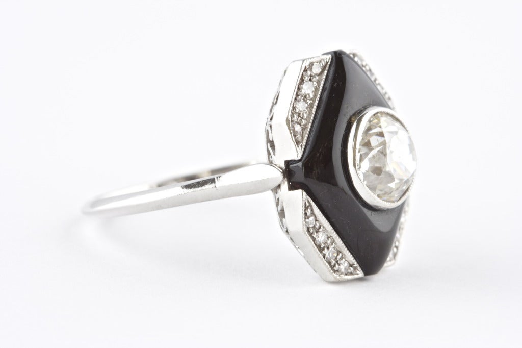 Art-Deco-Ring aus Platin mit einem Mittelstein von etwa 1::10 Karat. Ungefähr J Farbe und SI1 Klarheit. Mit Diamant-Akzenten. 

Ringgröße: 7.5 und kann in der Größe verändert werden.