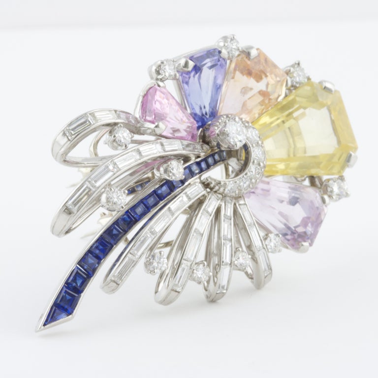 Signature Oscar Heyman brooch featuring multicolored sapphires and diamonds; the yellow sapphire weighs 10 carats.

Size: 1.25 x 2 inches
Weight: 26.2g